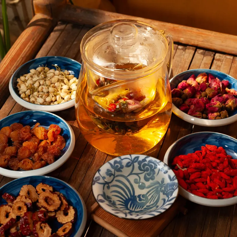 玻璃壺裡的花草茶，周圍擺著枸杞、紅棗等乾料